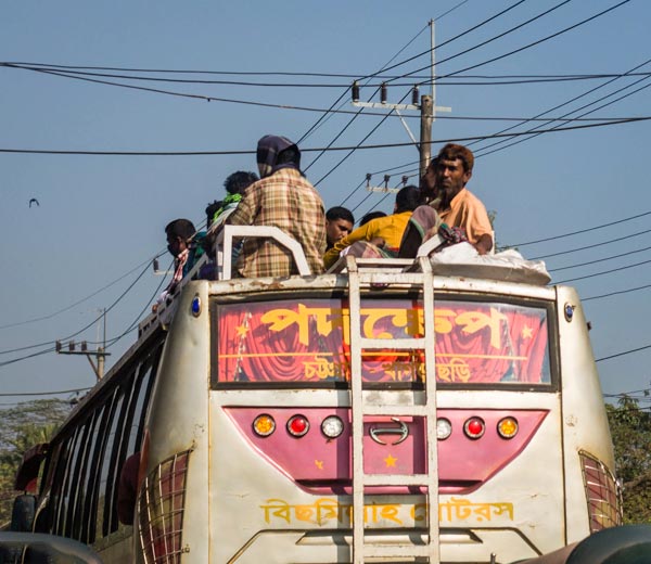 People riding on the roof of a bus in Bangladesh