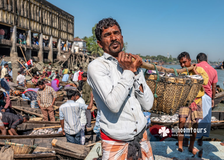 Carrying fish at a fishing harbor in Cox's Bazar